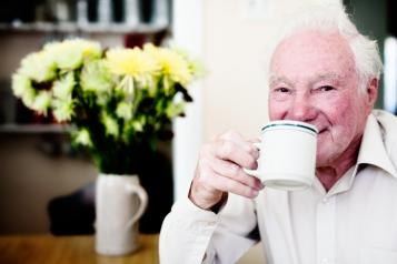 An older man drinking a cup of tea